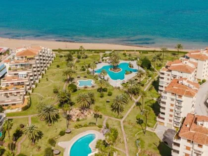 Primera línea de playa en Dénia – Terraza con vistas al mar y urbanización con piscinas